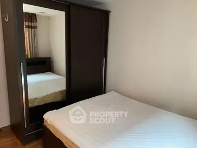 Cozy bedroom with mirrored wardrobe and comfortable bed