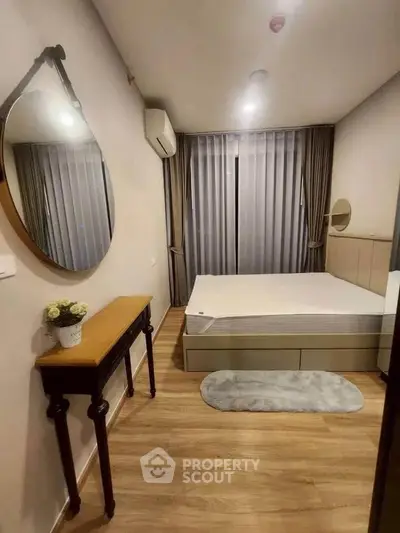 Cozy bedroom with modern decor, featuring a large mirror, wooden flooring, and elegant curtains.