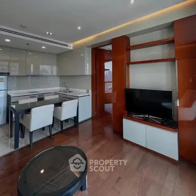 Modern living room with open kitchen, sleek cabinetry, and hardwood floors in a stylish apartment.