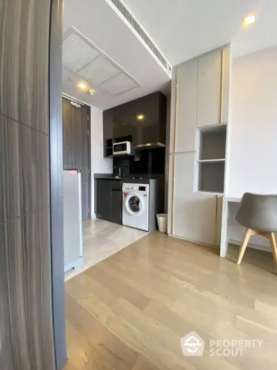 Modern compact kitchen with integrated washing machine and sleek cabinetry