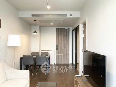 Modern living room with sleek furniture and dining area in a stylish apartment.