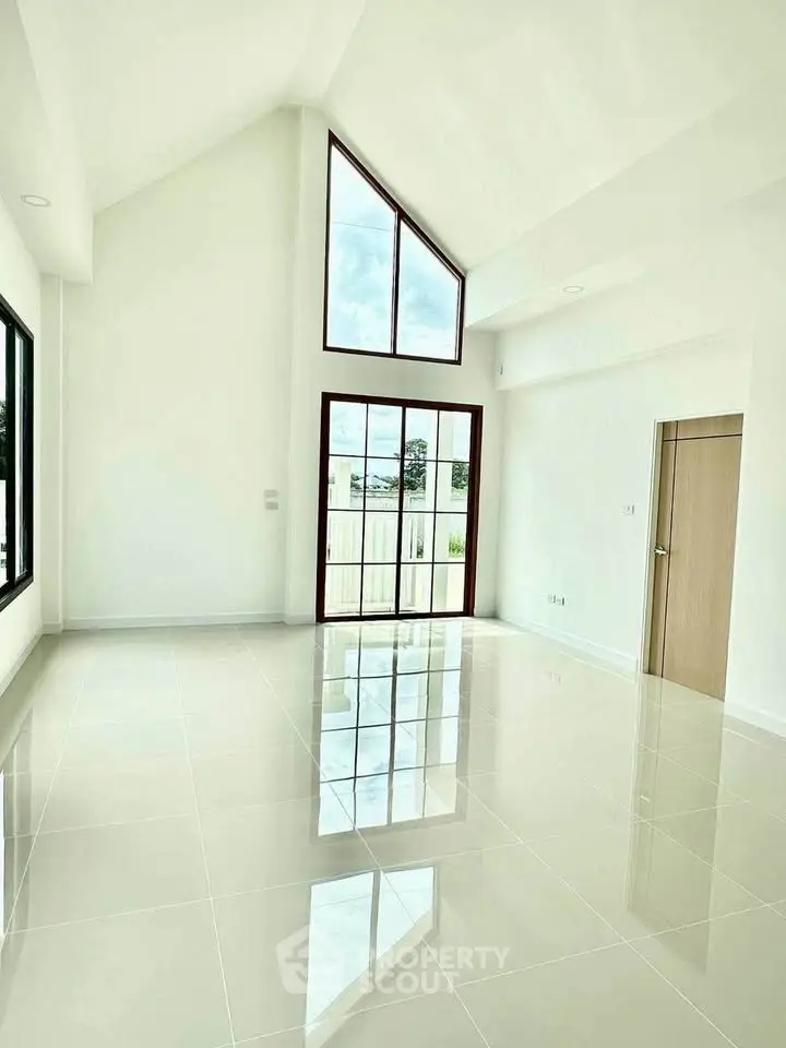 Spacious modern living room with high ceilings and large windows offering abundant natural light.