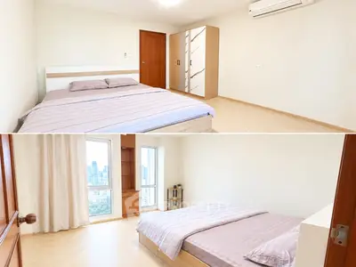 Spacious bedroom with city view, modern furnishings, and ample natural light.