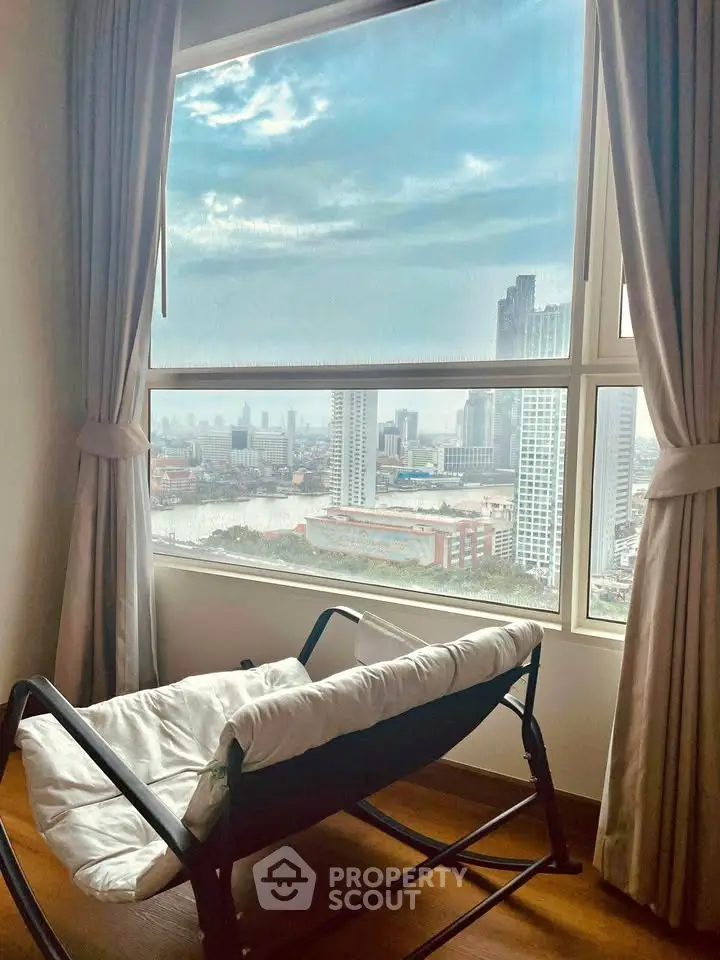 Stunning city view from a cozy room with large window and elegant curtains.