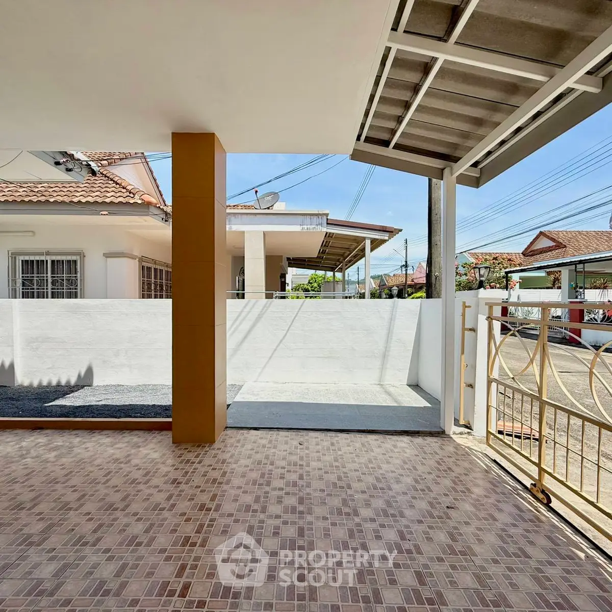 Charming residential entrance with tiled patio and gated access in a suburban neighborhood.