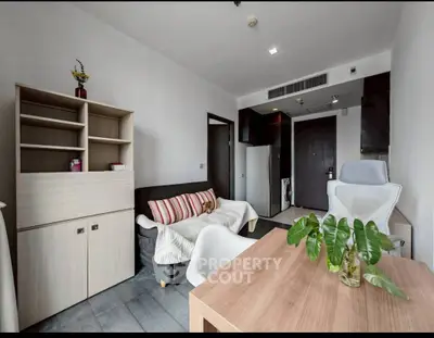 Modern living room with stylish furniture and natural light, perfect for relaxation and work-from-home setup.