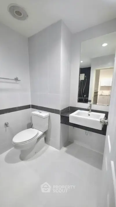 Modern bathroom with sleek design and white fixtures in a contemporary apartment.