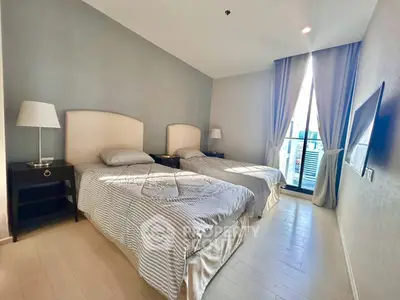 Modern bedroom with twin beds and balcony view in stylish apartment