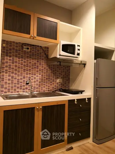 Compact kitchen with modern appliances and stylish backsplash