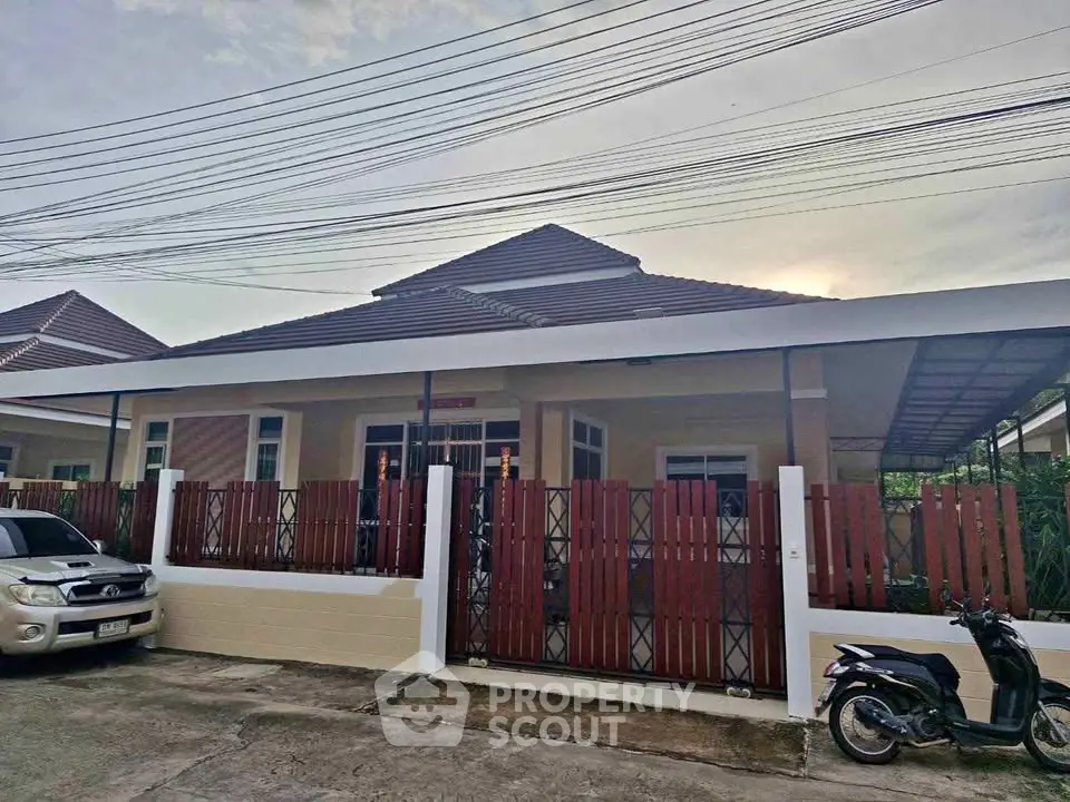 Charming single-story house with modern roof and gated entrance, perfect for cozy living.