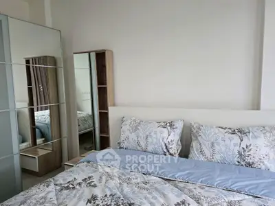 Cozy bedroom with floral bedding and mirrored wardrobe for modern living.