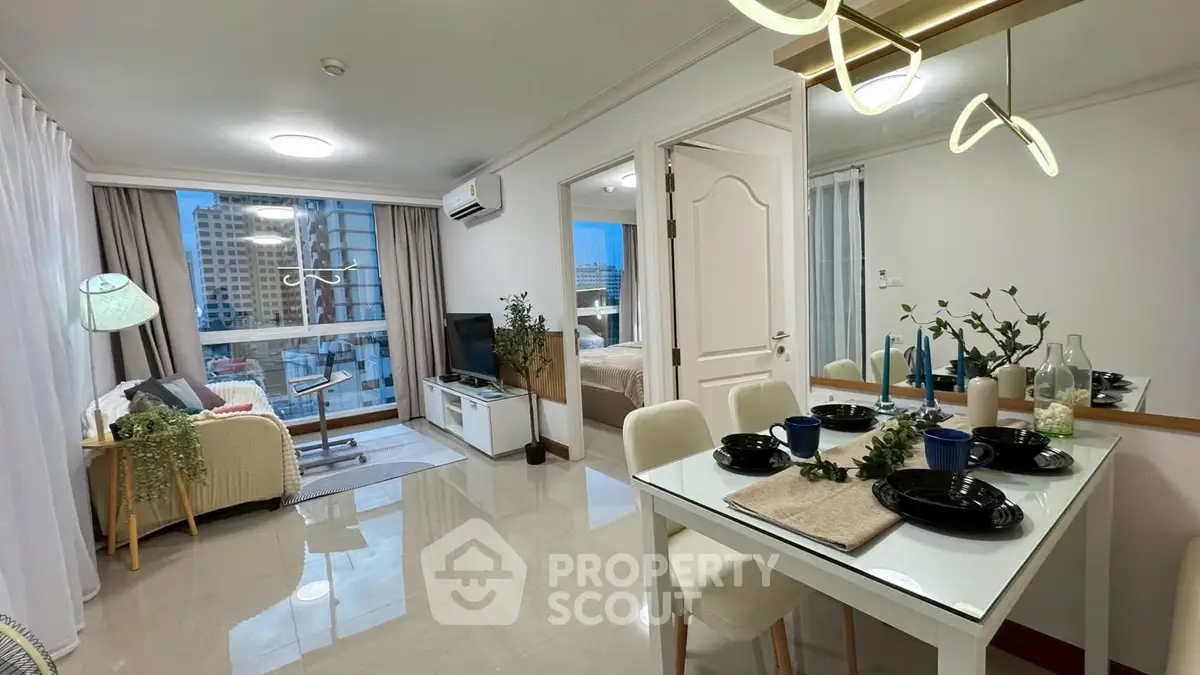 Modern open-plan living and dining area with city view, stylish decor, and natural lighting.