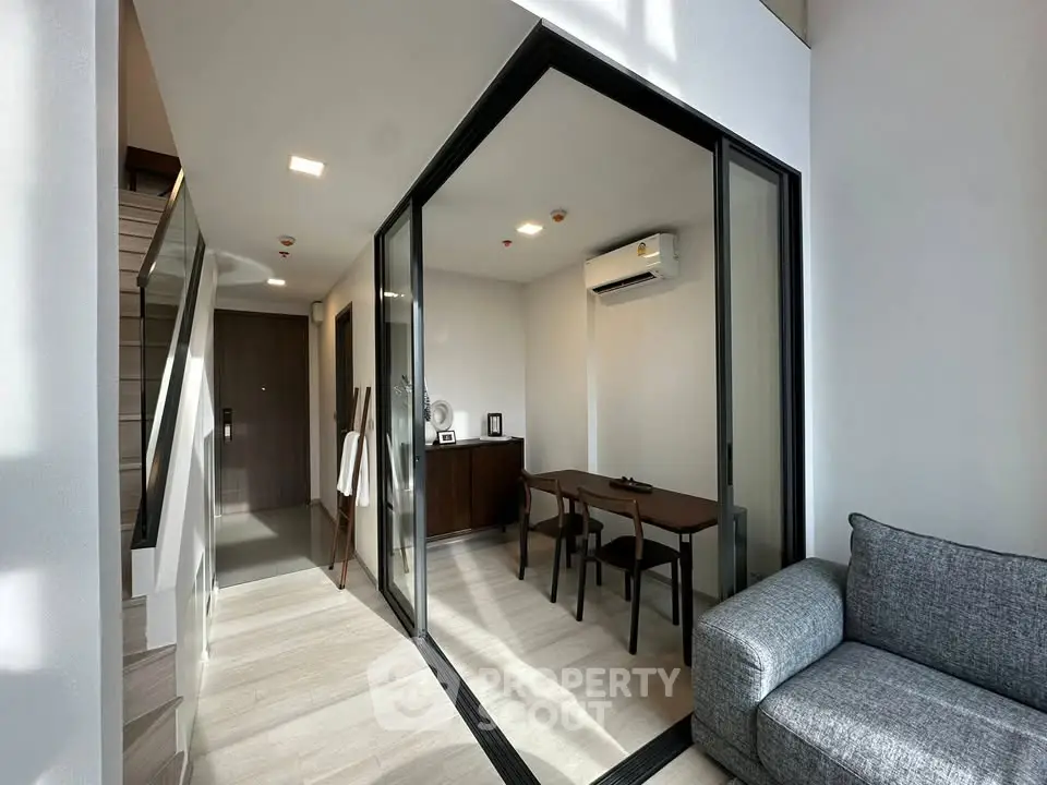 Modern living room with glass-enclosed study area and stylish furniture