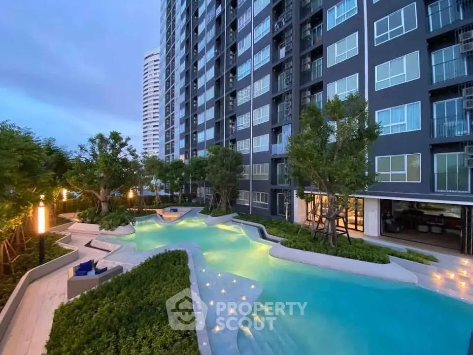Luxurious condominium with stunning pool and modern architecture at dusk.