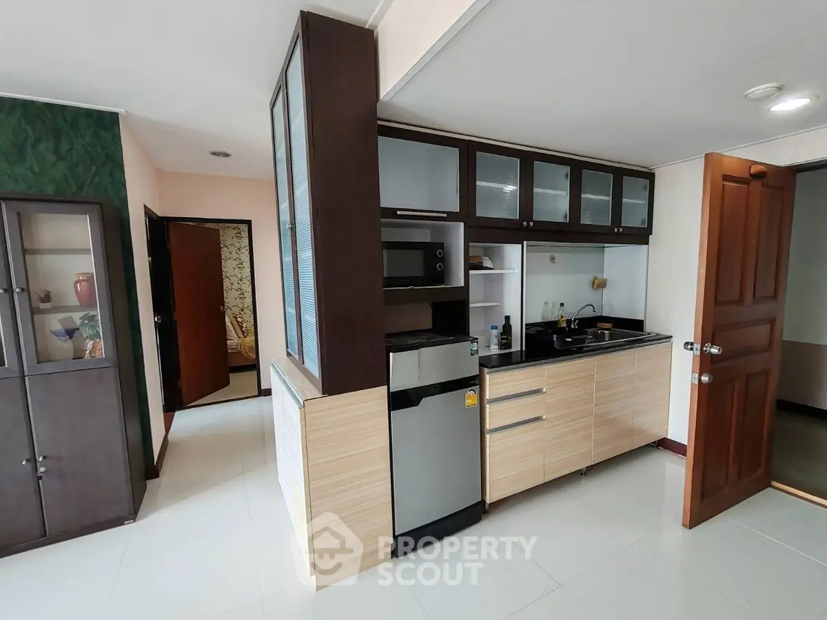 Modern kitchen with sleek cabinetry and stainless steel appliances in a stylish apartment.