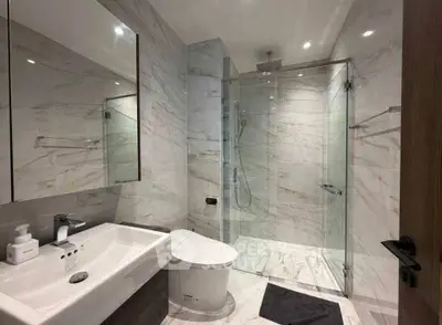 Luxurious modern bathroom with marble tiles and glass shower enclosure