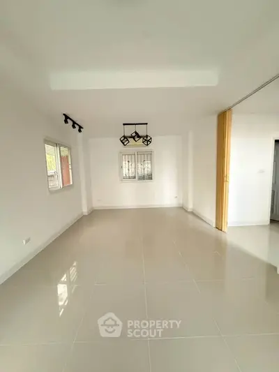 Spacious empty living room with modern lighting and large windows