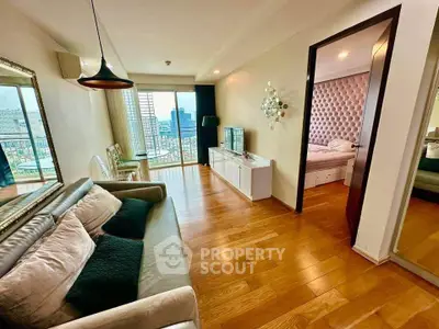 Spacious living room with wooden flooring and city view, adjacent to a stylish bedroom.