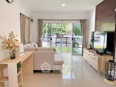 Modern living room with large windows and stylish furniture, offering a bright and inviting atmosphere.