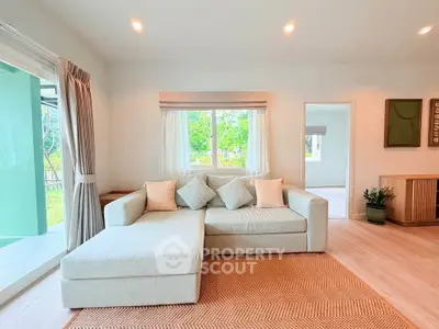 Spacious living room with modern decor and large windows offering natural light.