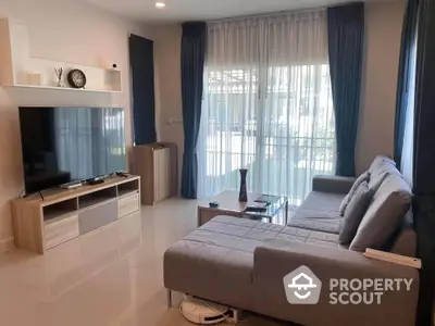 Modern living room with sleek furniture and large TV, perfect for relaxation and entertainment.