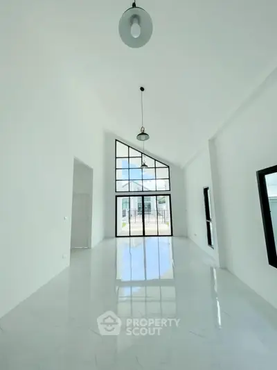 Spacious modern living room with high ceilings and large windows for natural light.