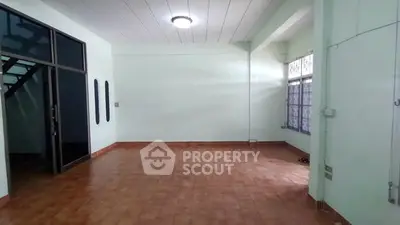 Spacious empty room with tiled floor and large windows, ideal for customization.