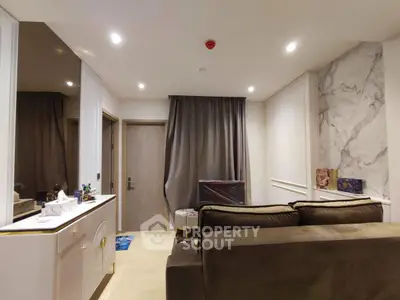 Modern living room with elegant marble accent wall and cozy seating area.