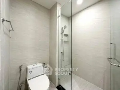 Modern bathroom with glass shower and sleek fixtures in a contemporary apartment.