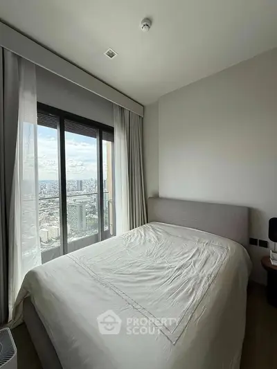 Modern bedroom with large window offering stunning city view, featuring a cozy bed and minimalist decor.
