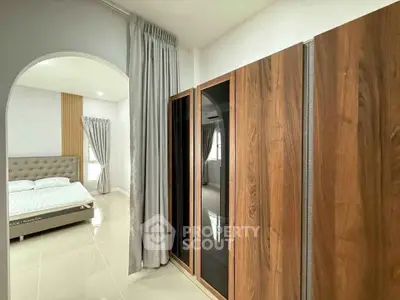 Modern bedroom with stylish wardrobe and elegant archway entrance.