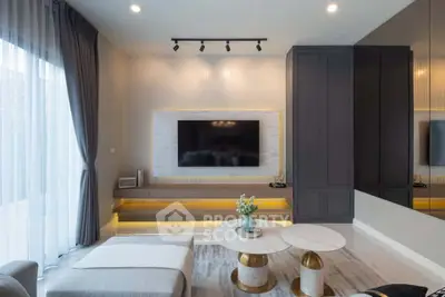 Modern living room with sleek design, featuring a large TV, elegant furniture, and ambient lighting.
