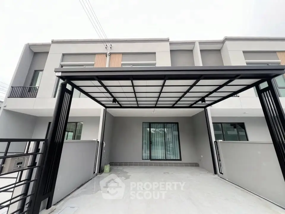 Modern townhouse exterior with covered parking and sleek design.