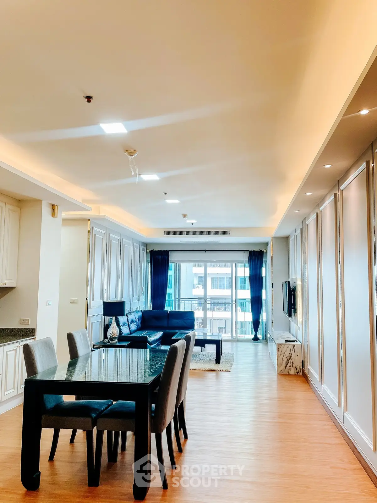 Spacious modern living room with elegant dining area and large windows in luxury apartment.