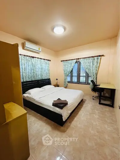 Cozy bedroom with air conditioning, double bed, and study desk, perfect for comfortable living.