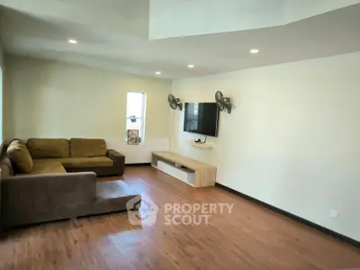 Spacious living room with modern decor and wooden flooring