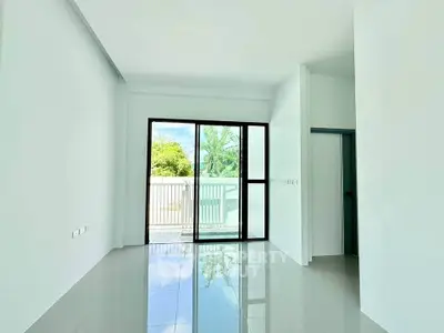 Spacious modern living room with large windows and balcony access, offering abundant natural light and serene views.