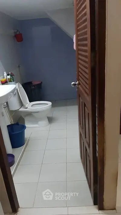 Cozy bathroom with essential fixtures and tiled flooring, ideal for compact spaces.