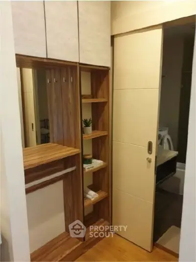 Modern interior with sliding door and wooden shelving unit in cozy apartment.
