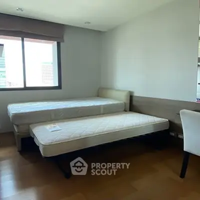 Spacious bedroom with twin beds and city view window