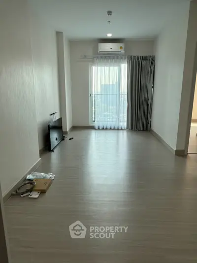 Spacious empty living room with large window and air conditioning