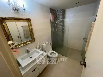 Elegant bathroom with vintage mirror and modern shower in stylish home.