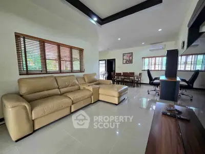 Spacious living room with modern leather sofa and elegant dining area, perfect for family gatherings.