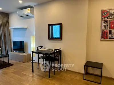 Modern living room with wooden flooring, compact dining area, and wall-mounted air conditioning.