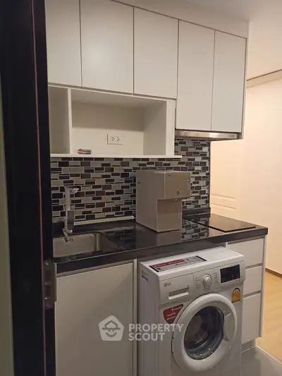 Modern kitchen with washing machine and sleek cabinetry