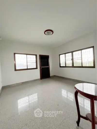 Spacious unfurnished room with large windows and natural light