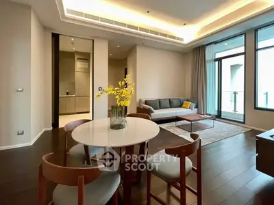 Modern living room with elegant dining area and large windows leading to balcony.