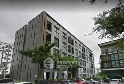 Modern apartment building with sleek design and large windows in urban setting.