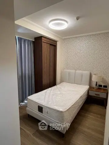 Cozy bedroom with modern lighting and elegant decor, featuring a comfortable bed and stylish wooden flooring.