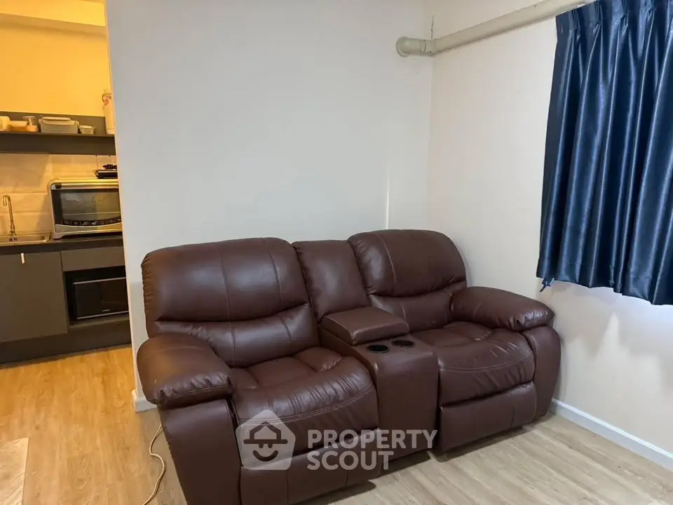 Cozy living room with leather recliner sofa and modern kitchen view